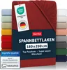 A red fitted sheet is displayed prominently, with a stack of other colored fitted sheets visible to the left and right. Anteprima dell’immagine prodotto