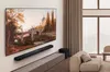 A modern living room with a large TV mounted on the wall, a soundbar below it, and a sofa to the side. Náhľad obrázku produktu