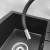 A close-up shot of a black kitchen sink with a flexible silver and black faucet. Náhľad obrázku produktu
