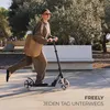 A woman riding a scooter in a park. Náhled obrázku produktu