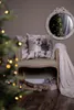 A cozy Christmas scene with a bench, pillows, a blanket, and logs. Podgląd zdjęcia produktu