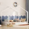 A child's bedroom with a white house-shaped bed frame, decorated with nautical-themed items.