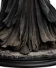 A close-up view of the base and lower robes of a dark, detailed statue, with a single foot visible. Podgląd zdjęcia produktu