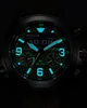 A close-up shot of a glowing watch face in the dark. Podgląd zdjęcia produktu