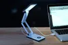 A white LED desk lamp is plugged into a laptop on a wooden desk. Produktbild-Vorschau