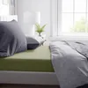 A neatly made bed with green fitted sheets and gray pillows and duvet. Produktbild-Vorschau