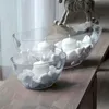 Two clear glass bowls filled with white stones and white candles are placed on a wooden surface. Anteprima dell’immagine prodotto