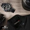 A collection of items for a motorcyclist, including a watch, gloves, and jacket, laid out on a wooden surface. Voir les images du produit