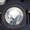 A table setting with plates, cutlery, and a charger plate. Anteprima dell’immagine prodotto