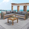 An outdoor patio setting with a view of the ocean, featuring a four-piece garden lounge set and a coffee table. Podgląd zdjęcia produktu