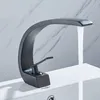 A black faucet is installed on a white sink, with water running from the faucet. Podgląd zdjęcia produktu