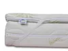A close-up view of a mattress topper with an aloe vera pattern and a label. Produktbild-Vorschau