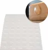 A sheet of clear adhesive bumper pads with a close-up inset showing one pad applied to the corner of a wooden surface. Produktbild-Vorschau