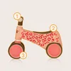 A pink balance bike with leopard print, featuring numbered callouts. Náhled obrázku produktu