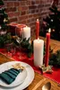 A festive Christmas table setting with candles, greenery, and a place setting. Produktbild-Vorschau
