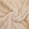 A close-up view of a soft, textured beige blanket. Anteprima dell’immagine prodotto