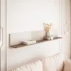 A minimalist shelf with decorative items above a sofa. Náhled obrázku produktu