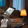 A person is holding a smartphone with a smart home app open, with a lamp and furniture in the background. Náhľad obrázku produktu
