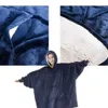 A woman wearing a dark blue hooded blanket with a large front pocket, with close-up shots of the blanket's fabric and lining. Anteprima dell’immagine prodotto