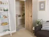 A room with a door open to a small office space, featuring a desk and a ladder shelf. Produktbild-Vorschau