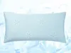 A light blue pillow with snowflake patterns on a background of ice cubes and water. Produktbild-Vorschau