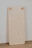 A wooden climbing board with various handholds, leaning against a wall. Voir les images du produit