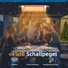 A group of friends are gathered around a table on a patio at night, enjoying themselves. A patio heater is mounted overhead, emitting warmth and light. There are decorative lights and a Christmas tree in the background. Náhľad obrázku produktu