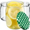 Three glass jars, one filled with lemon slices and liquid, and a green checkered lid. Podgląd zdjęcia produktu