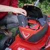 A person is inserting a battery into a red lawnmower. Anteprima dell’immagine prodotto