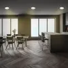 A modern dining and kitchen area with a dining table and chairs, and a bar with stools. Produktbild-Vorschau
