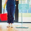 A person in blue overalls and yellow gloves is holding a red bucket and a mop, standing on a wooden floor. Produktbild-Vorschau