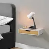 A floating bedside shelf with a drawer and a lamp on it, next to a bed. Podgląd zdjęcia produktu