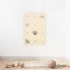 A wooden climbing wall with gray climbing holds is mounted on a white wall above a wooden floor. Two wooden dumbbells and a textured ball are on the floor. Voir les images du produit