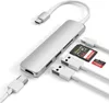 A silver USB-C hub with various ports and cables, along with two memory cards, is displayed against a white background. Voir les images du produit