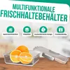 A clear glass food storage container with oranges inside, placed on a wooden surface. The background is blurred. Produktbild-Vorschau