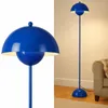 A collage showing a close-up of a blue floor lamp and a full shot of the lamp in a room. Produktbild-Vorschau