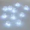 A string of white starburst-shaped LED lights on a light gray background. Produktbild-Vorschau