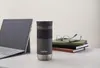 A Contigo travel mug is placed on a desk next to a laptop and a stack of books. Podgląd zdjęcia produktu