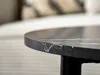 Close-up of the edge of a round black marble coffee table with white veining. Produktbild-Vorschau