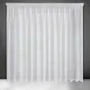 A white curtain hanging against a dark gray wall and a white floor. Produktbild-Vorschau