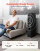 A man is sitting on a couch next to a speaker, with sound waves emanating from the speaker. Produktbild-Vorschau
