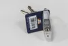 A silver padlock with two keys attached to a blue tag, lying on a white surface. Produktbild-Vorschau