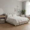 A bedroom scene with a bed, vanity, and plant. Náhľad obrázku produktu