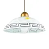 A pendant light fixture with a white glass shade decorated with a black geometric pattern and a gold cap. Podgląd zdjęcia produktu