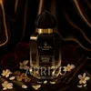 A bottle of El Nabil Royal Gold perfume is displayed on a dark, luxurious fabric background, surrounded by roses, vanilla beans, and small white flowers. Voir les images du produit