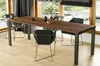 A dining table with chairs in a well-lit room with large windows overlooking a garden. Anteprima dell’immagine prodotto