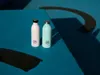 Two water bottles on a blue surface with shadows. Produktbild-Vorschau