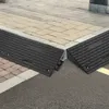 Two black rubber ramps are placed on a sidewalk at a street corner. Náhled obrázku produktu