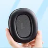 A hand holding a black ear pad with a gray fabric insert marked with an 'L'. The background is a soft blue with light blue shadows. Voir les images du produit