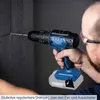 A person is using a cordless drill to drill into a dark wall. Produktbild-Vorschau